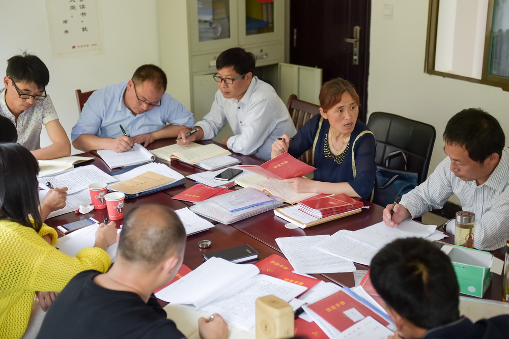 安徽潜山县水吼镇三里村党支部书记汪义琴（右二）在三里村村委办公室与同事们就下一步扶贫工作展开讨论（5月6日摄）。