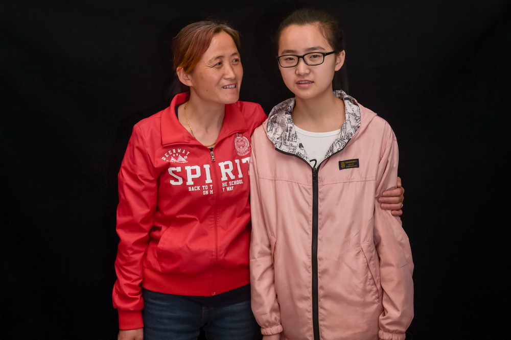 安徽潜山县水吼镇三里村党支部书记汪义琴（左）在潜山县野寨中学与小女儿徐可合影（5月7日摄）。