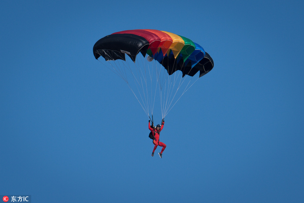 武汉开发区汉南通航机场上空，随着一架运-12飞过，天空中此地展开一朵朵降落伞，现场玩起“仙女散花”，“世界飞行者大会”跳伞运动员抵达现场并进行了试跳。