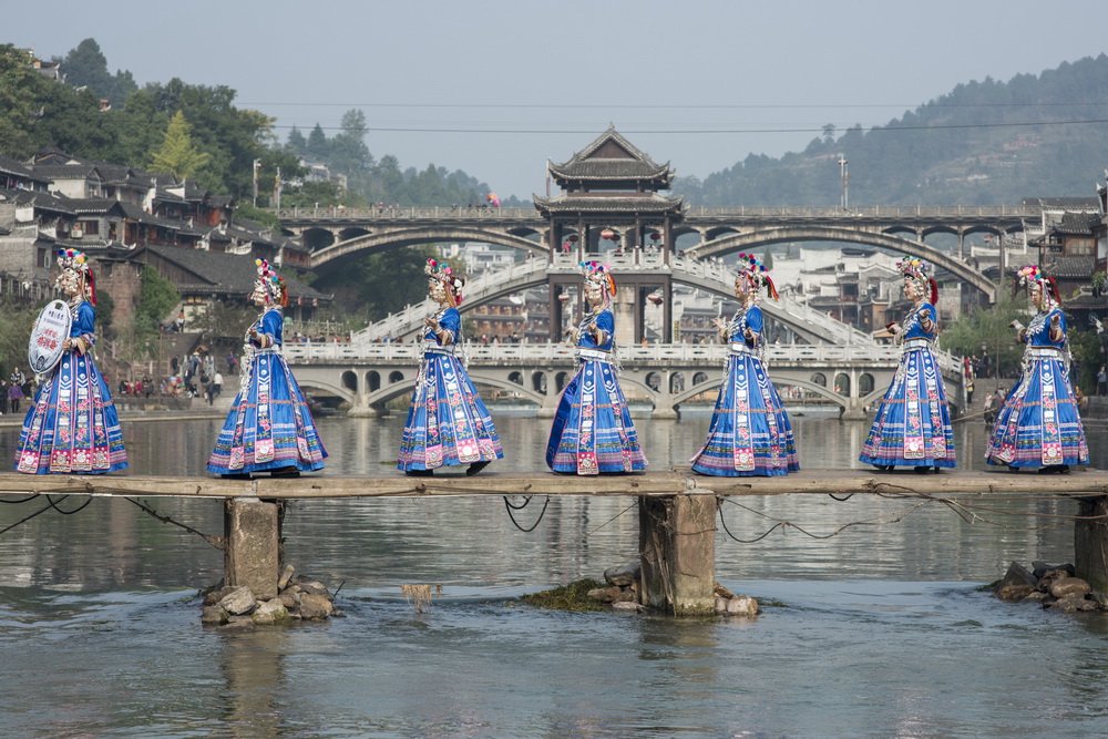 10月29日，湖南靖州苗族侗族自治县的苗家姑娘走上古城内的木板桥进行服饰展示。