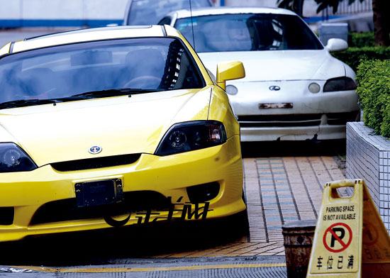 淘金小区车位紧张业主路边停车 拆车牌躲罚单