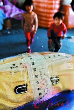 市质监局工作人员在用于抽样检查的纤维制品上贴上了抽样封样单。 记者庄小龙 摄 市质监局工作人员在用于抽样检查的纤维制品上贴上了抽样封样单。 记者庄小龙 摄