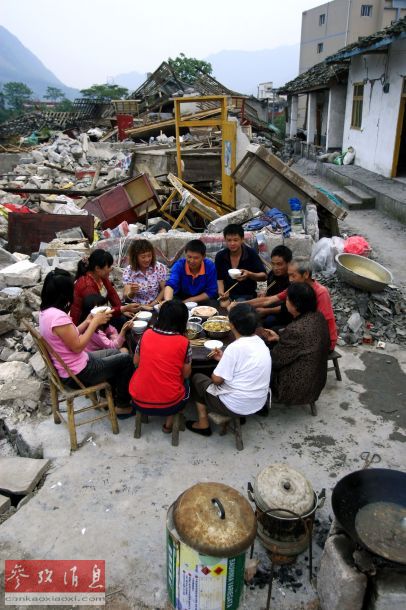 2008年5月23日傍晚,在四川什邡市 华镇地震灾区,一户灾民在自家的废墟