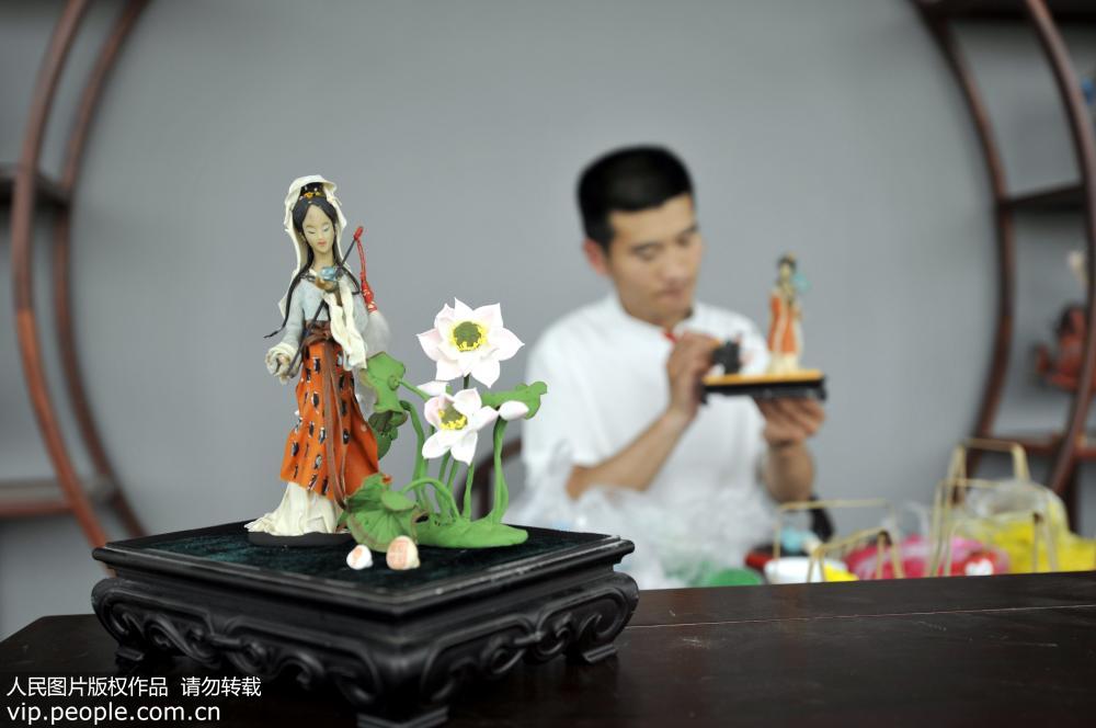 5月14日，山东省郯城县面塑传承人韩红元在创作捏制面塑作品《红楼梦系列人物》。