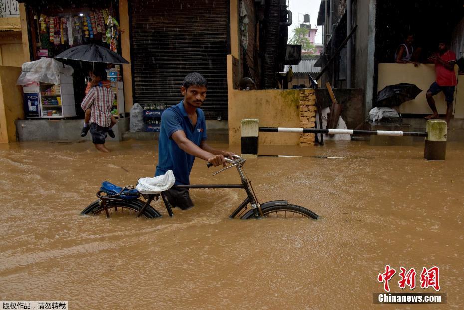 印度进入季风雨季 大雨如注民众涉水出行
