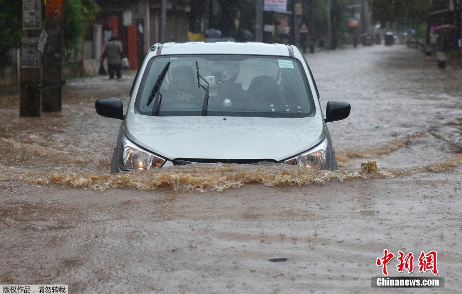 印度进入季风雨季 大雨如注民众涉水出行