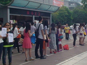 广交会明天开幕 美女大学生齐聚展馆外“揽生意”